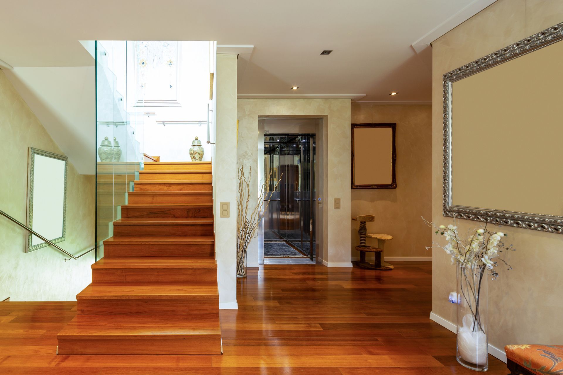 Wooden staircase inside a modern home with wood flooring and neutral-colored walls.
