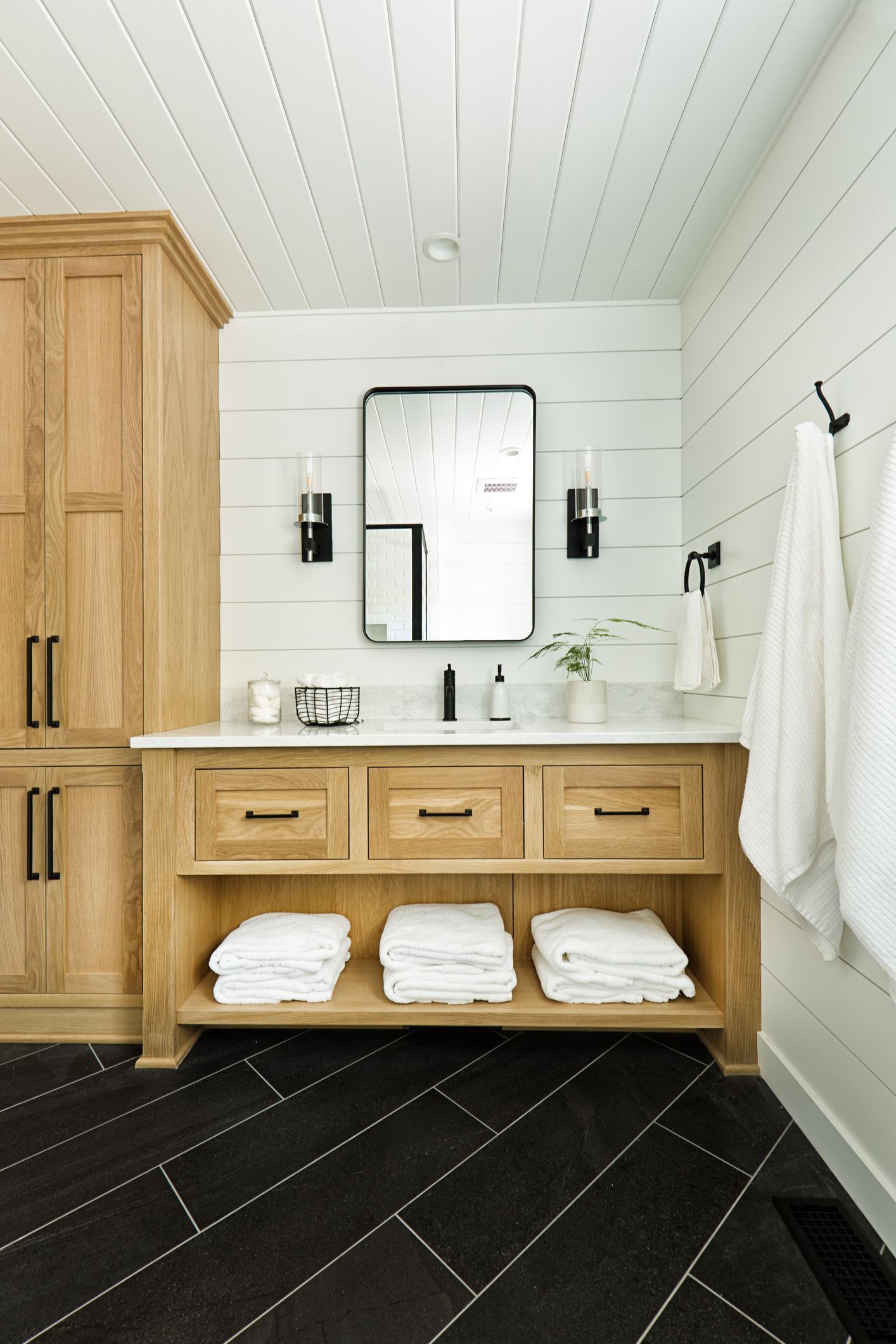 A bathroom featuring a tiled shower with glass doors and a jacuzzi tub.  Red towels hang by the window.