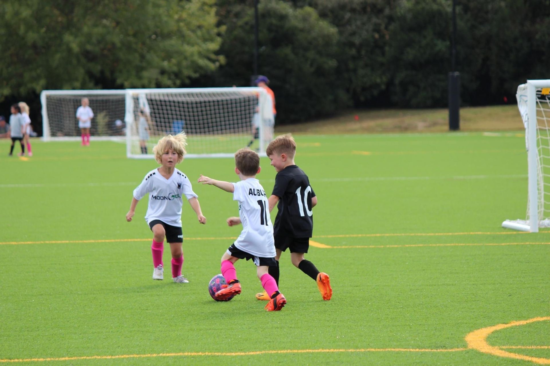 Three children play soccer 