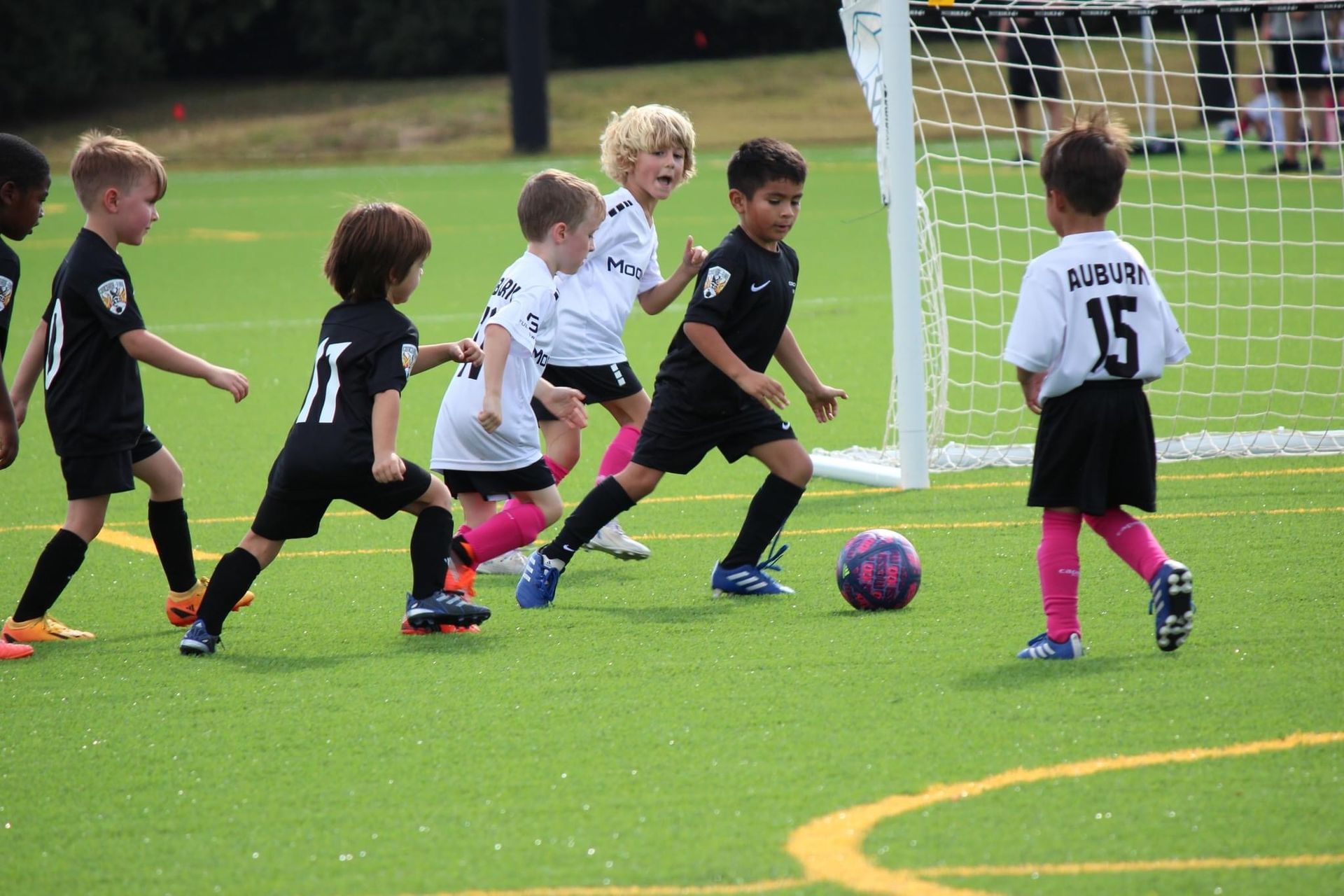 A group of young soccer players in a game