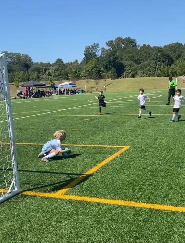 A youth goalkeeper making a save