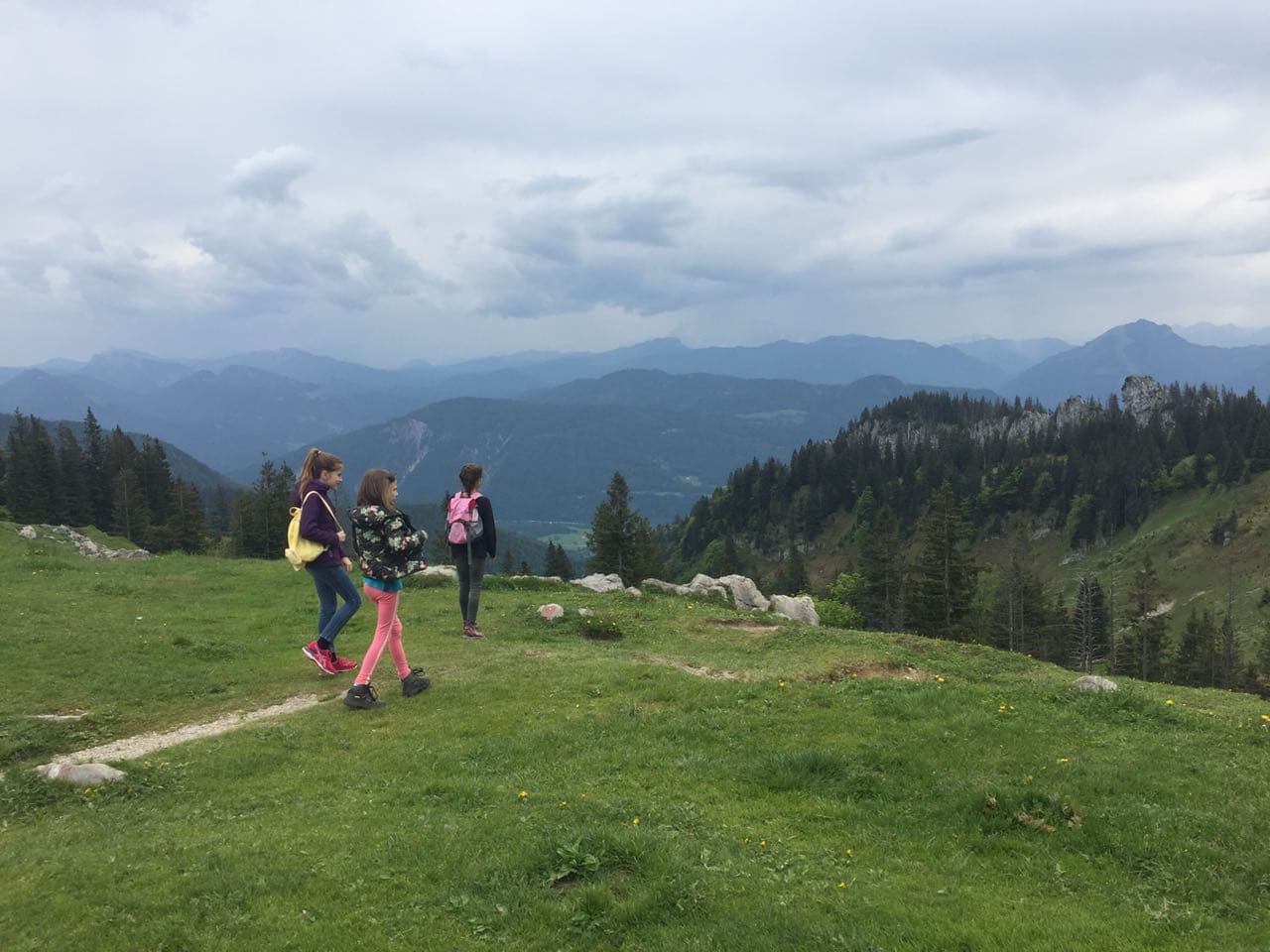 Eine Gruppe von Menschen geht auf einem Pfad in den Bergen spazieren.