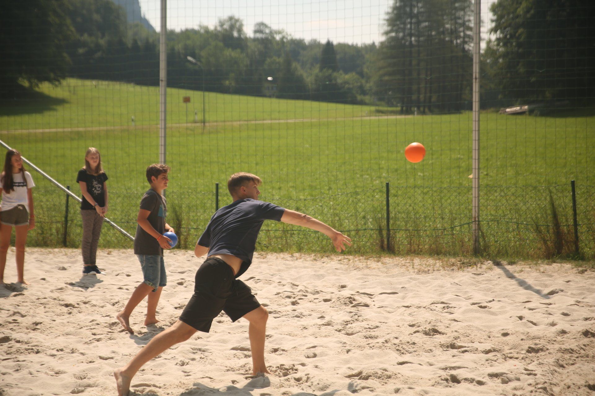 Eine Gruppe von Menschen spielt Volleyball im Sand.