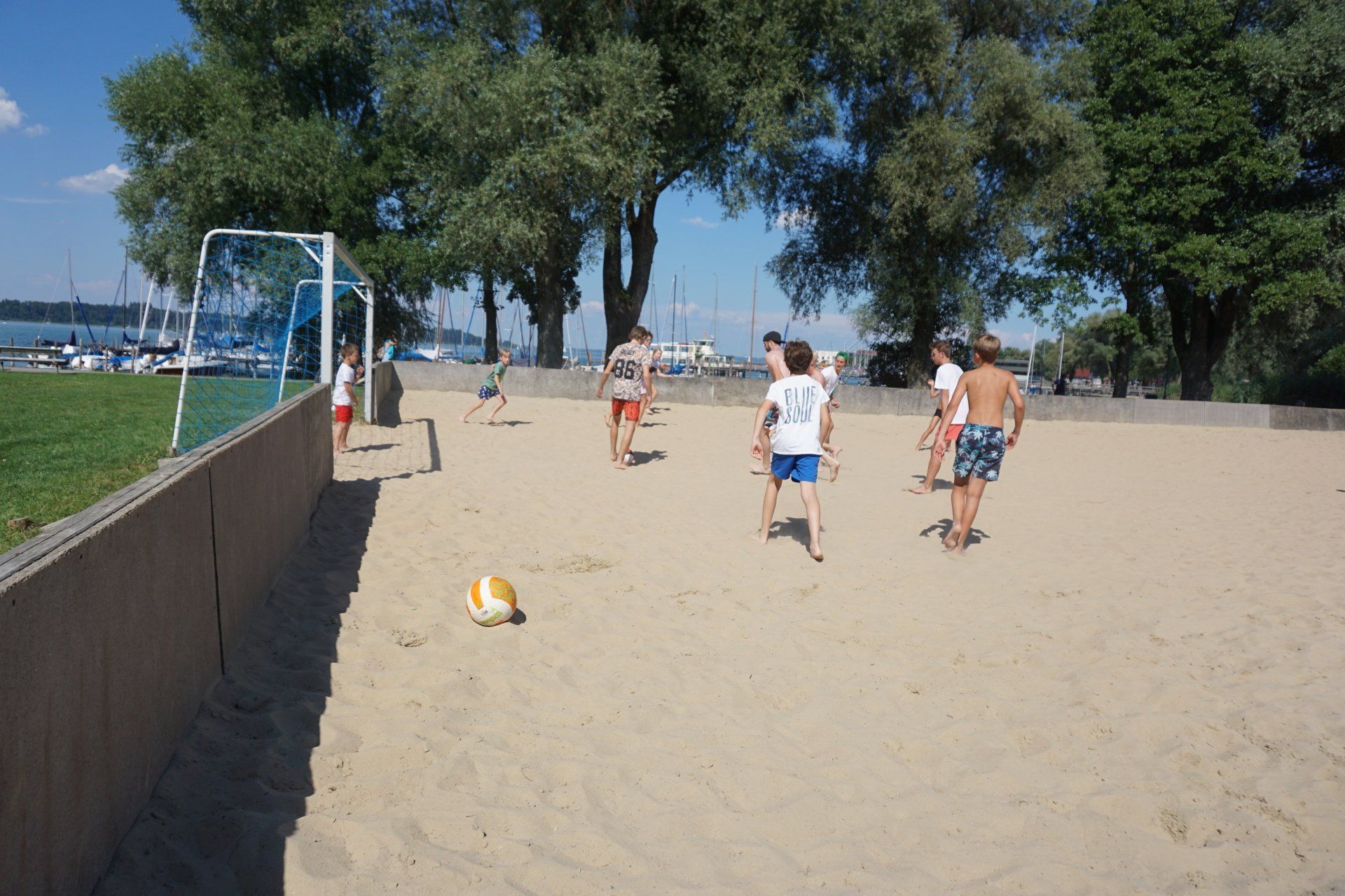 Eine Gruppe von Menschen spielt Volleyball an einem Sandstrand.