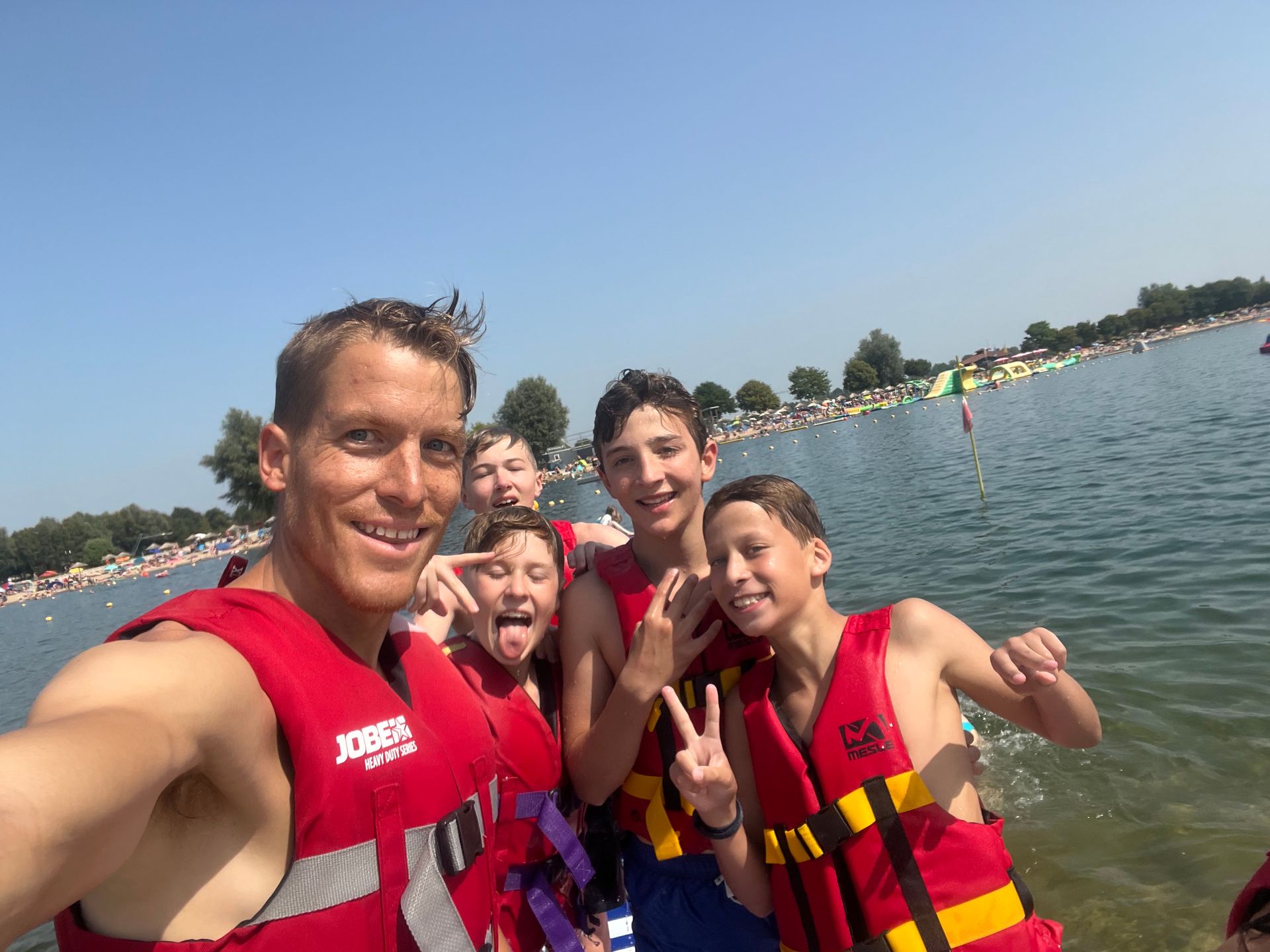 Eine Gruppe von Menschen in Schwimmwesten auf einem Gewässer macht ein Selfie.