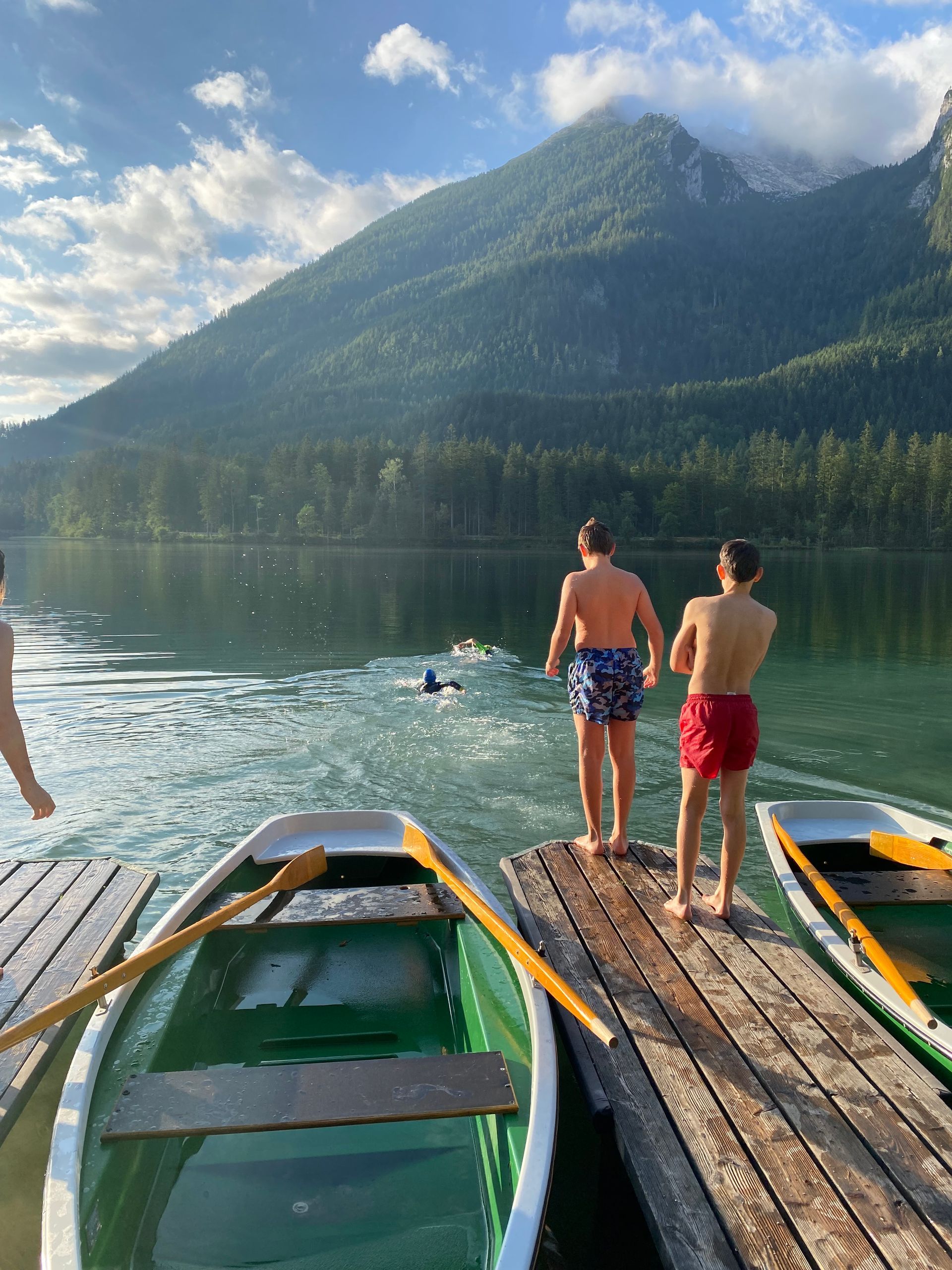 Zwei Männer stehen auf einem Steg und blicken auf einen See