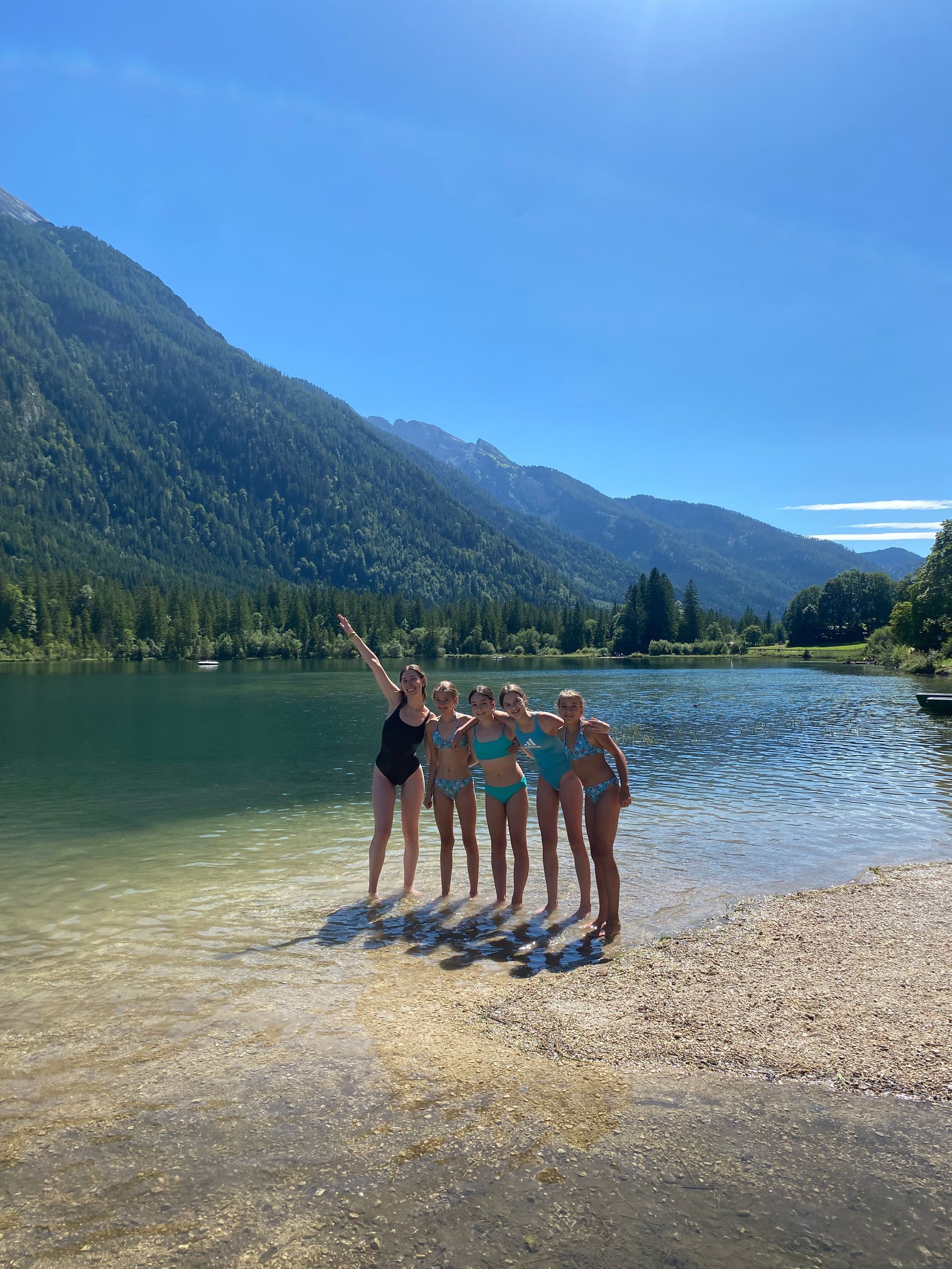 Eine Gruppe Frauen posiert für ein Foto am Ufer eines Sees.