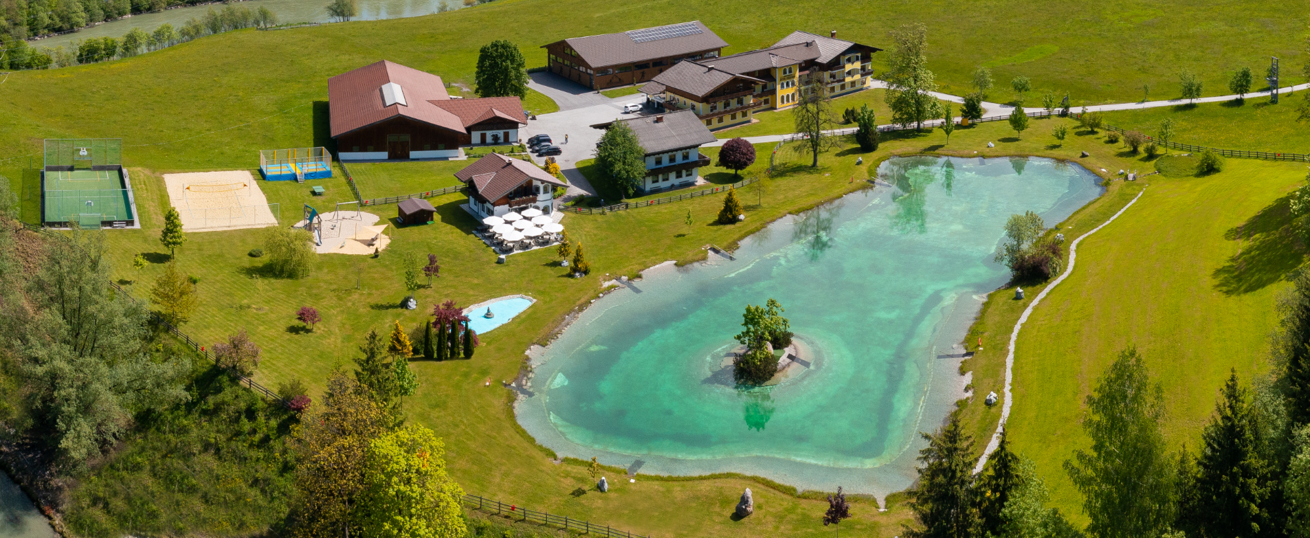 Eine Luftaufnahme eines Hauses mit einem großen Teich in der Mitte