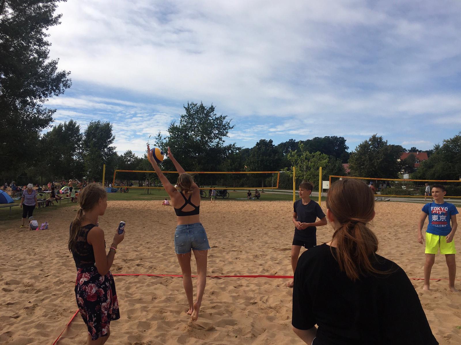 Eine Gruppe von Menschen spielt Volleyball an einem Sandstrand