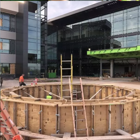 A construction site with a large building in the background