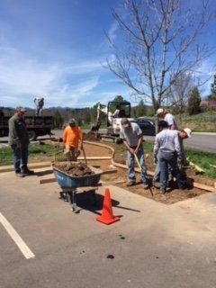 Man Holding Wheel Barrow — Horseshoe, NC — Carolina Concrete Designs Inc