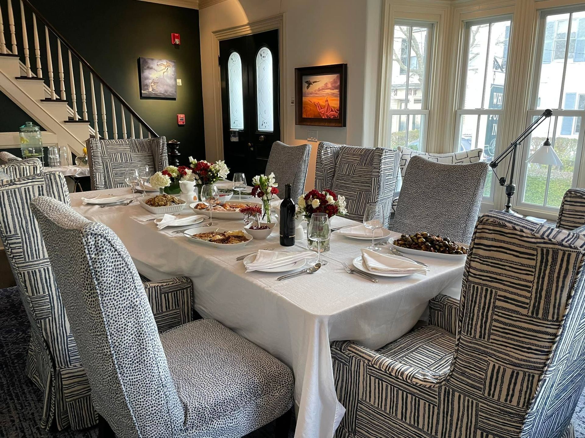 A dining room with a long table and chairs set for a meal.