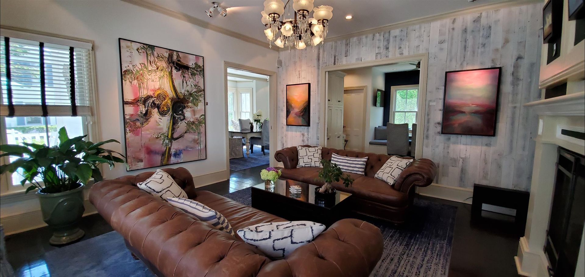 A living room with a brown couch , two chairs , a coffee table , and a fireplace.