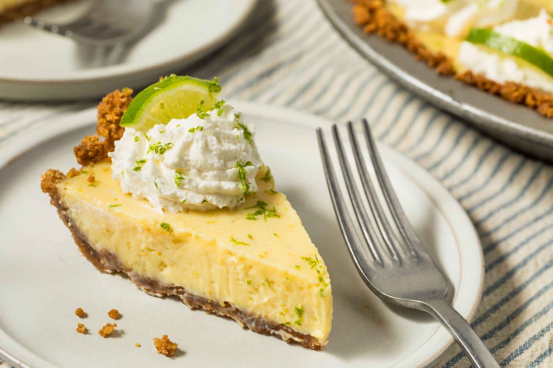 A slice of key lime pie on a plate with a fork.
