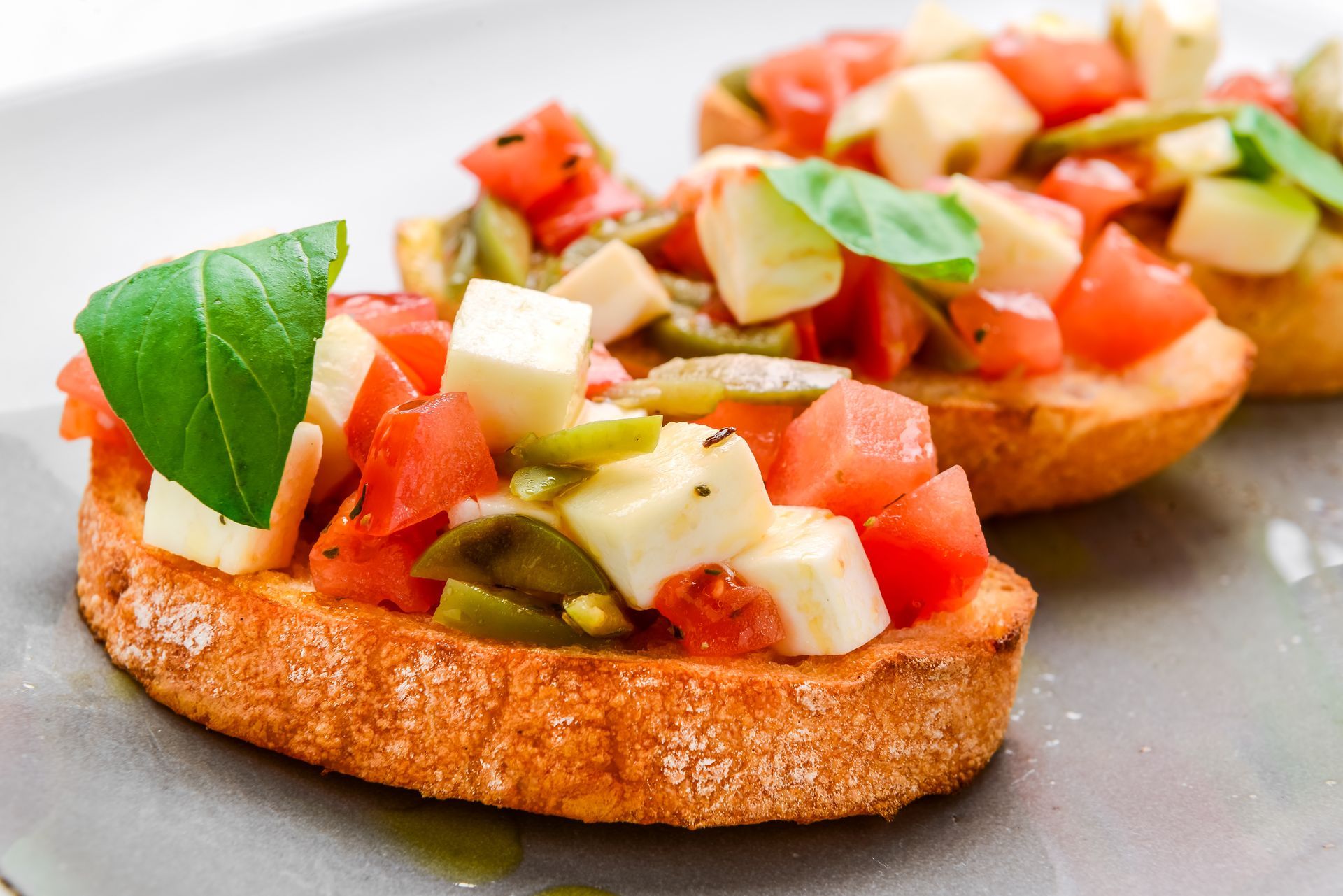 A close up of a sandwich with tomatoes and cheese on a plate.