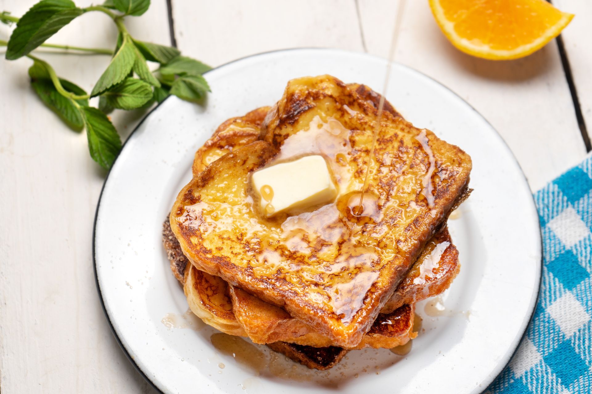 French toast with butter and syrup on a white plate.