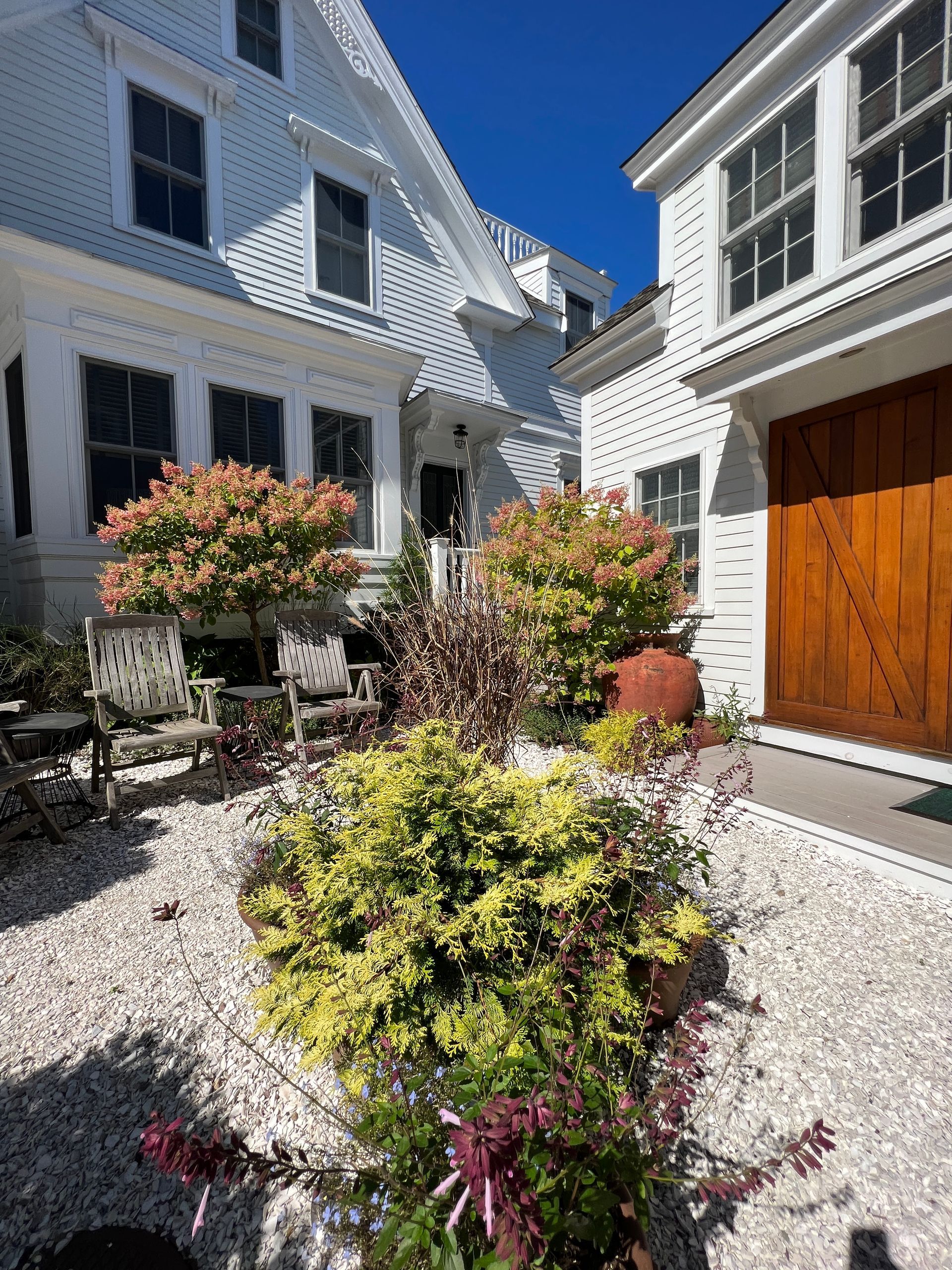 Exterior picture of the garden in front of the carriage house and main house.