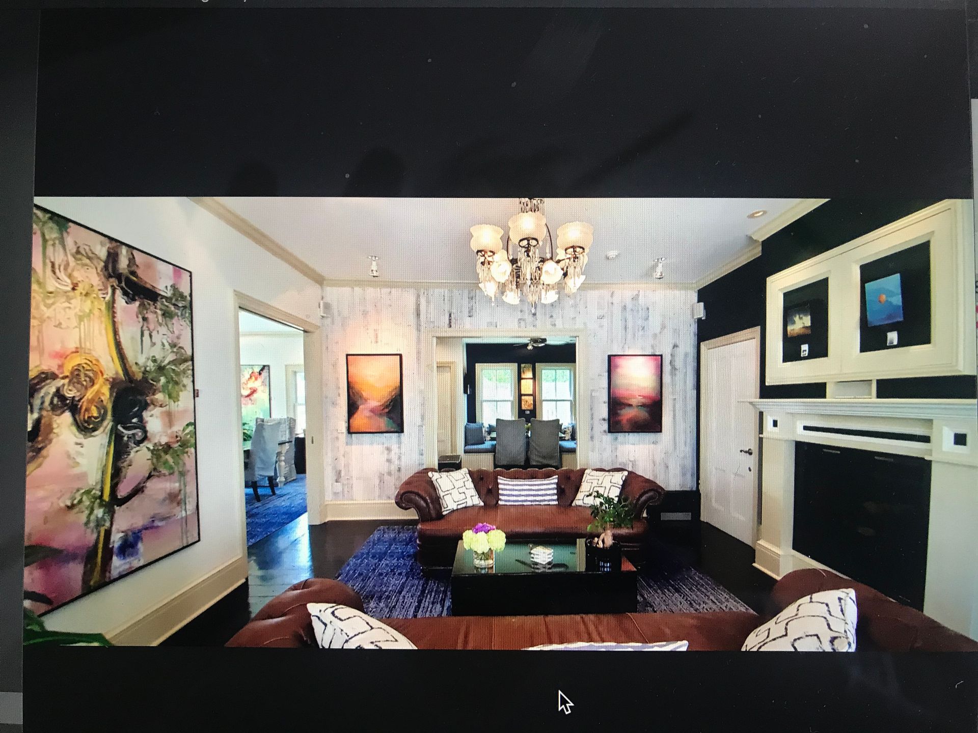 Sitting room with fireplace, two sofas and art.