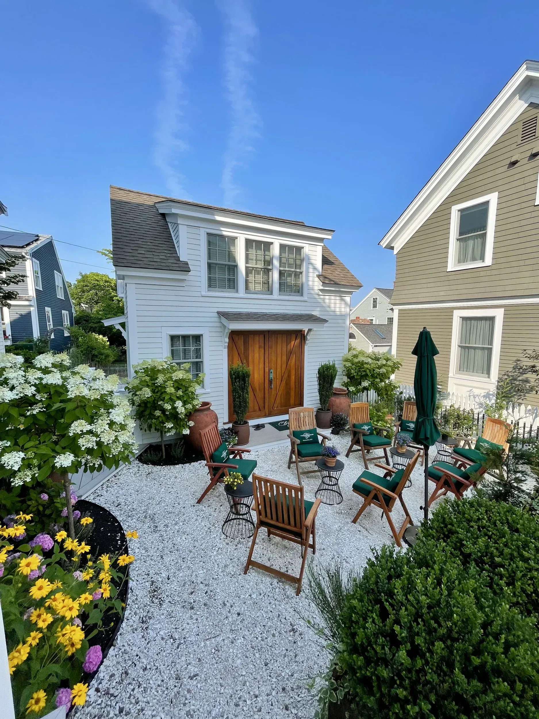 Exterior picture of the carriage house with double wooden barn doors ands garden.