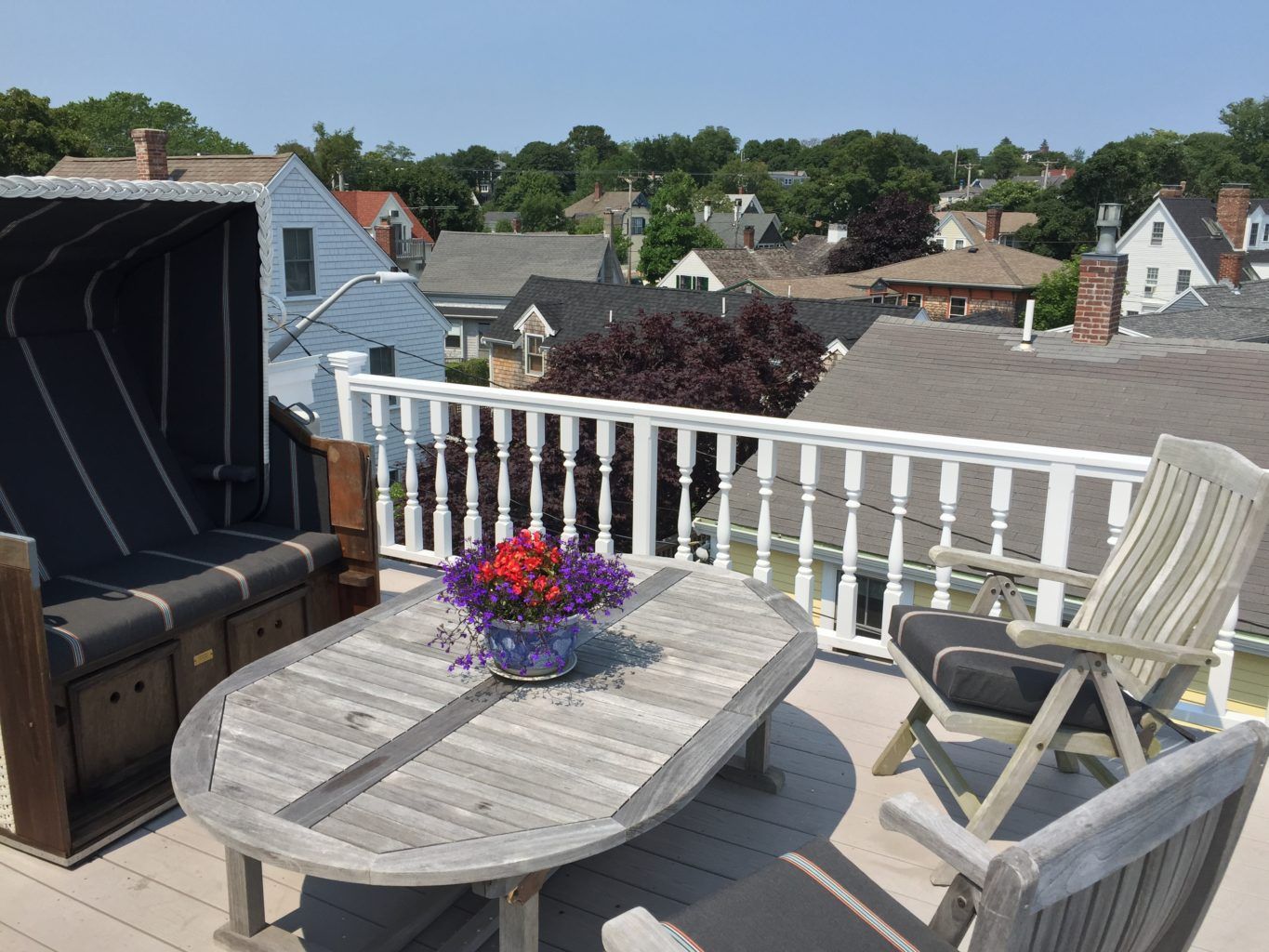 A table and chairs on a balcony overlooking town.