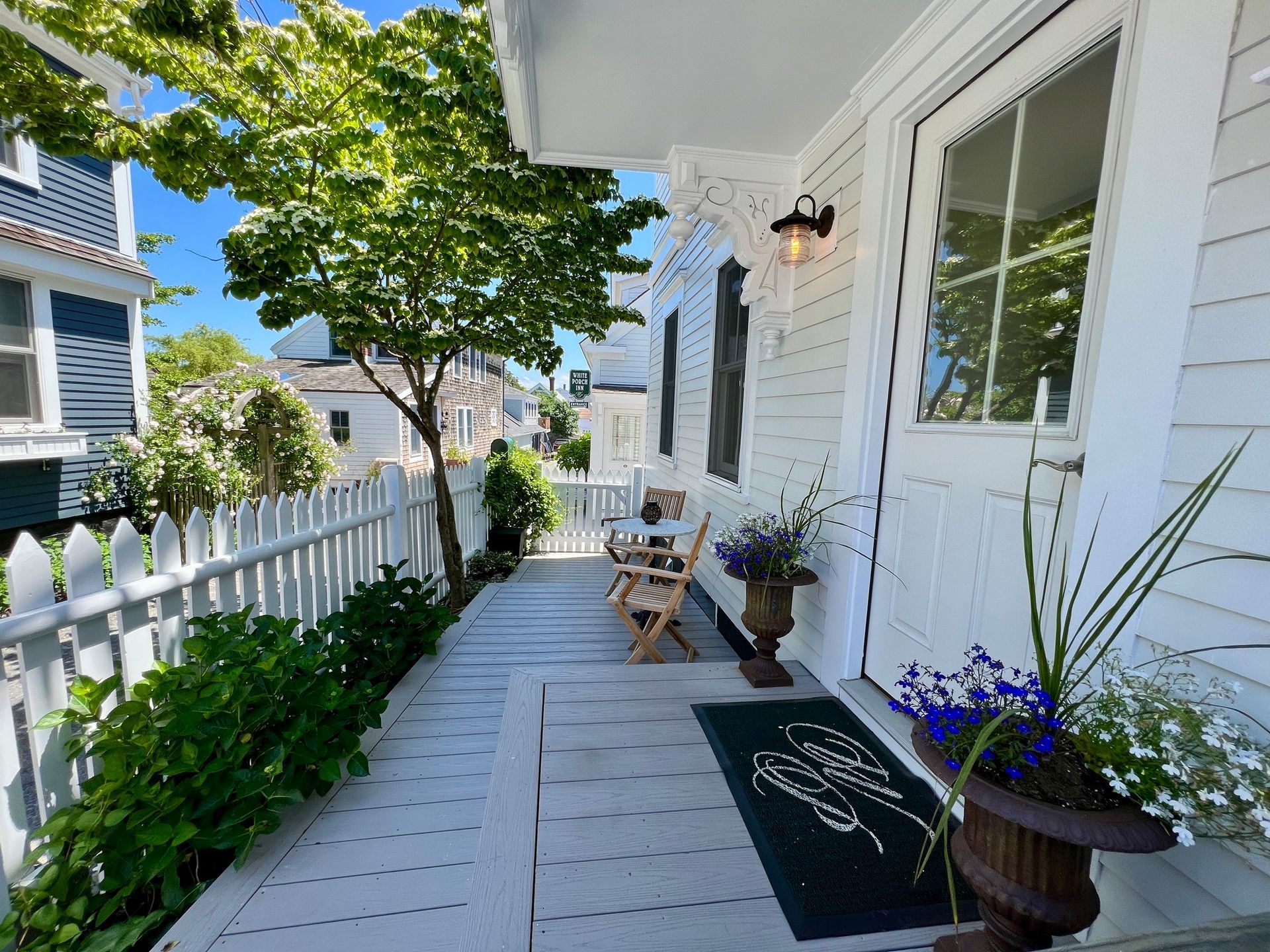 A white house with a white picket fence and a porch