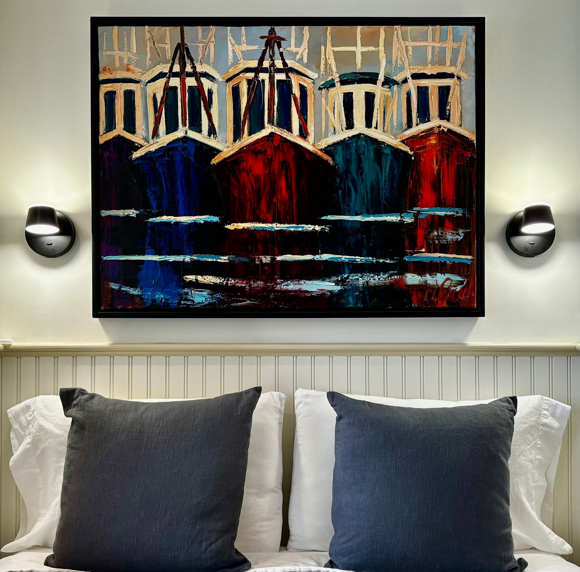 A painting of the Provincetown fishing boats hangs above a bed