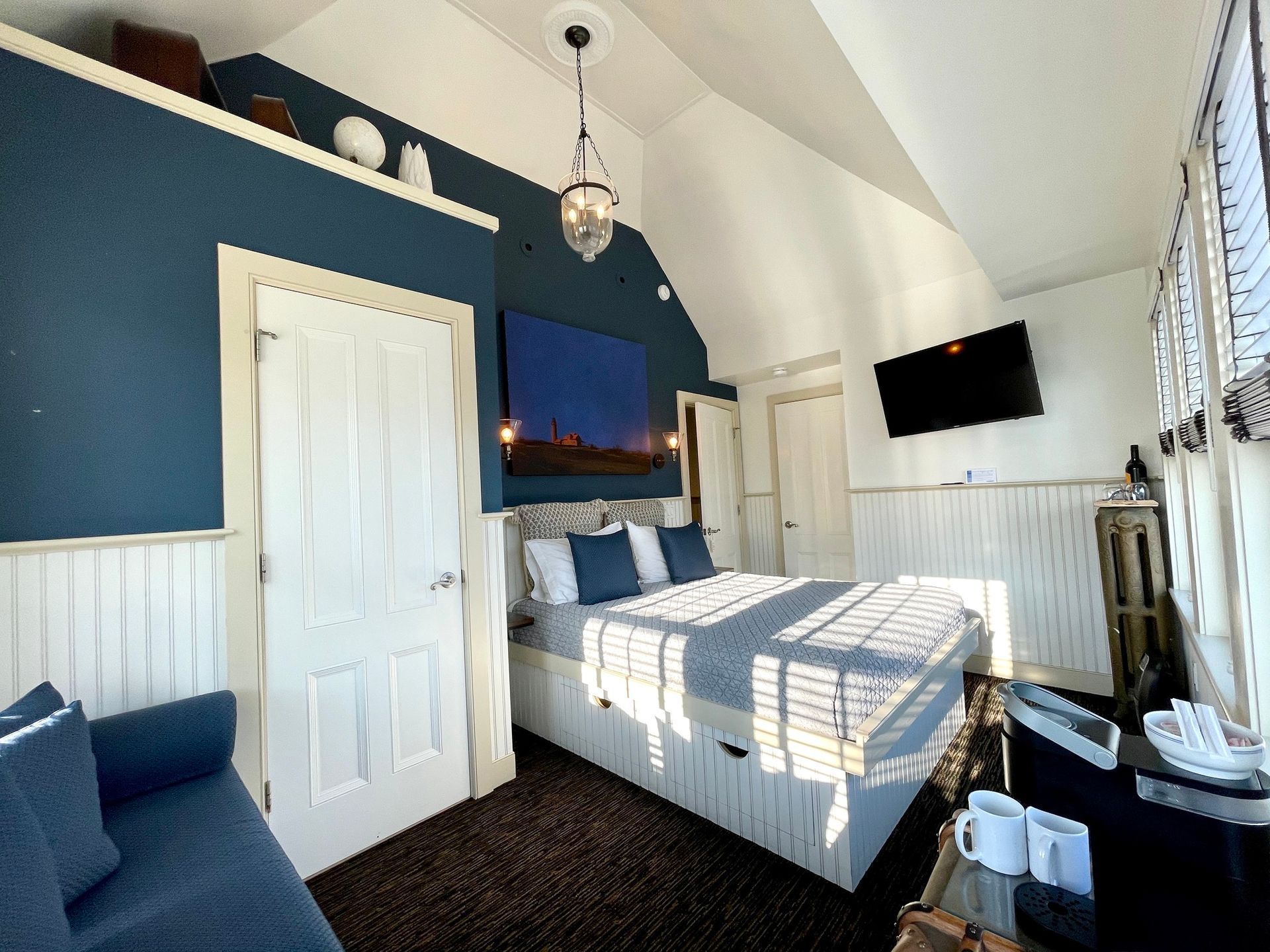 Interior Room picture with blue wall, white door, bed and high ceilings.