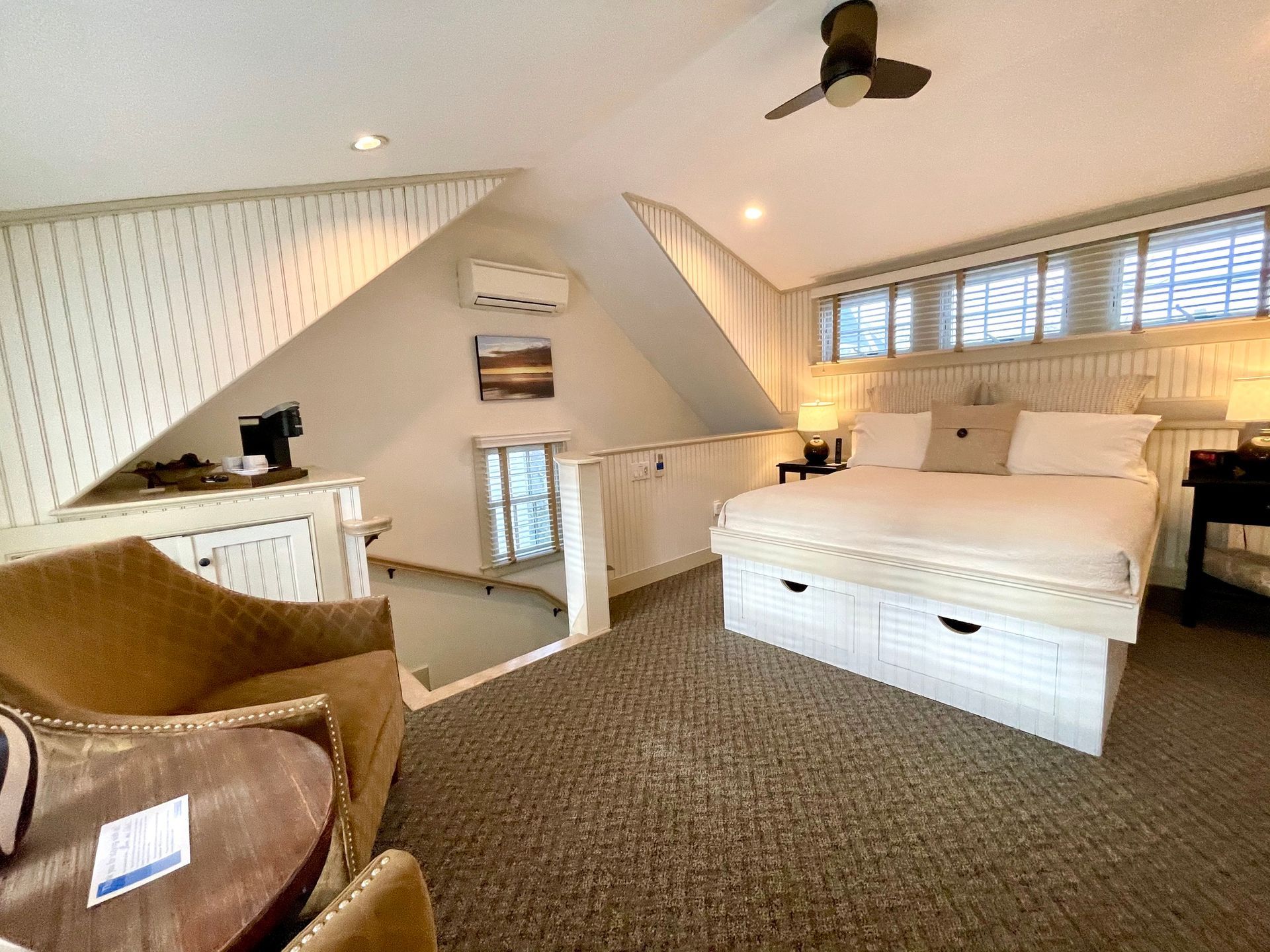A bedroom with a king size bed and a ceiling fan.