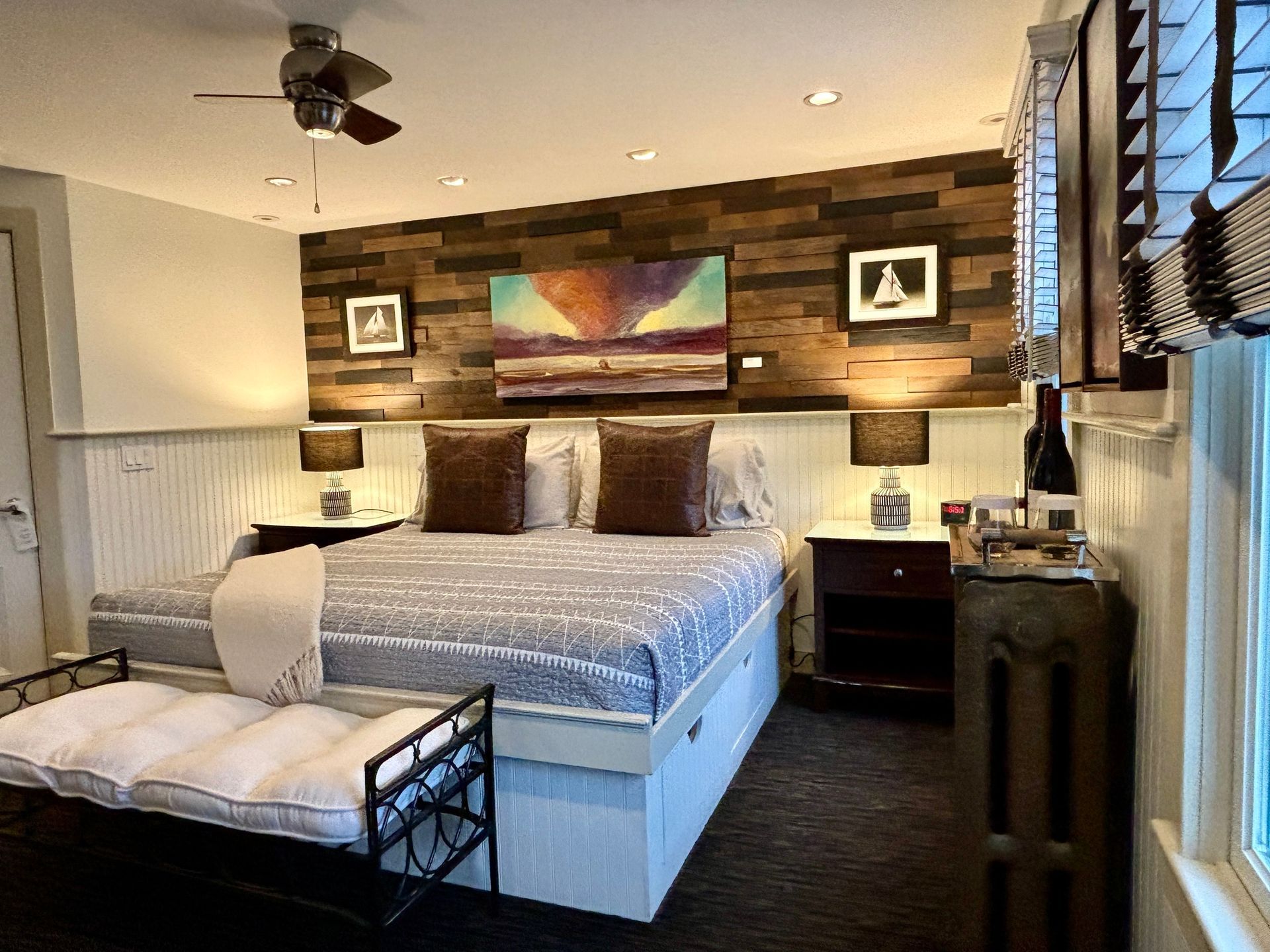 Interior room picture of wooden wall with painting hanging over a bed