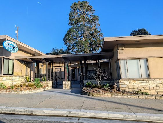 A large brown building with a tree in front of it.