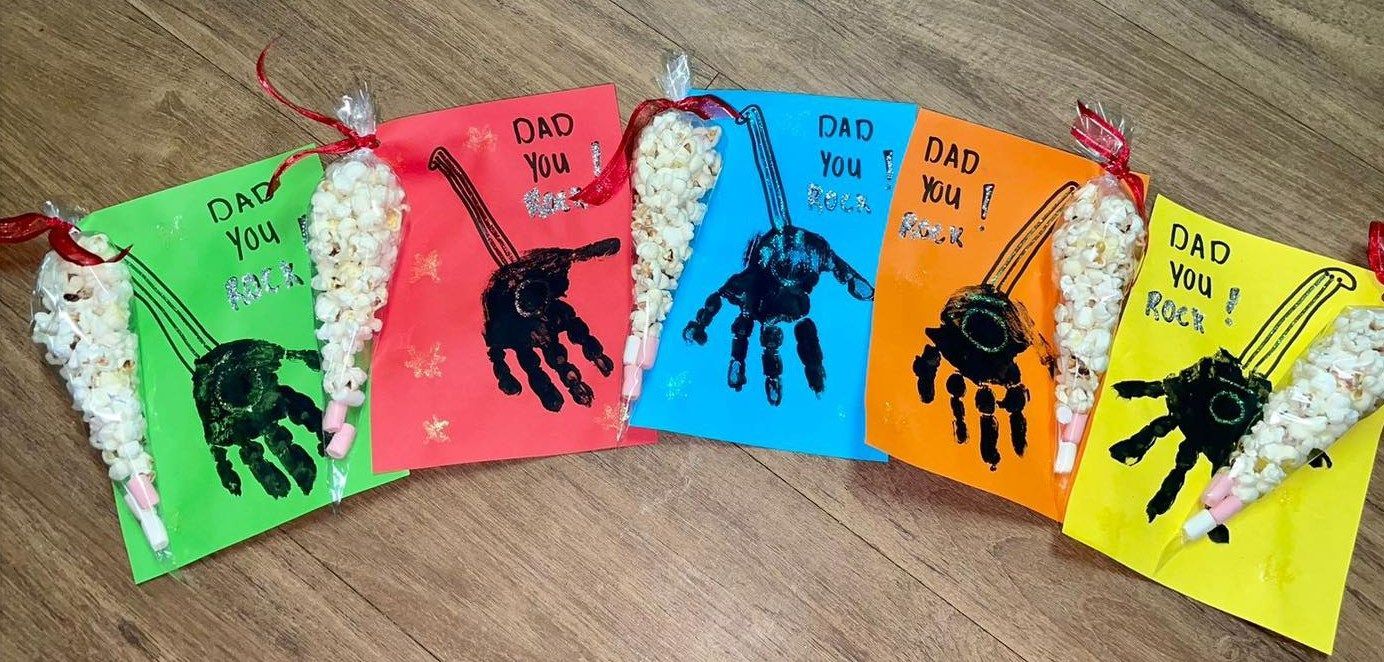 Colorful cards with handprint art and treats, possibly for a Father's Day gift.