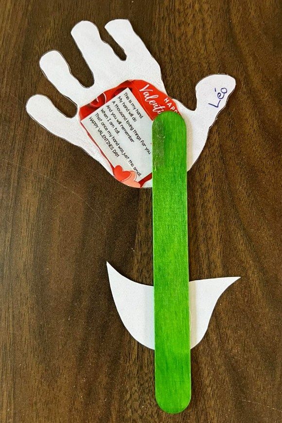 A handmade dove Valentine's Day card with a green popsicle stick.