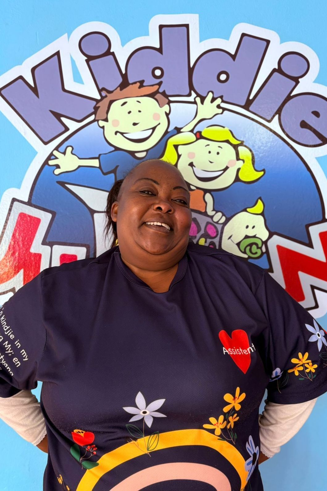 Woman in blue shirt smiles in front of 