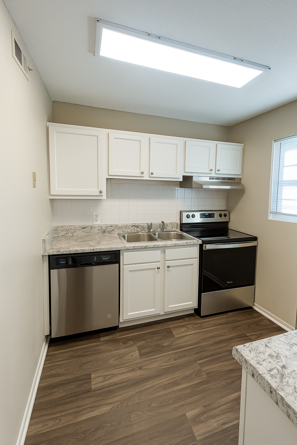 Kitchen with white cabinets, stainless steel appliances, and wood-look flooring.