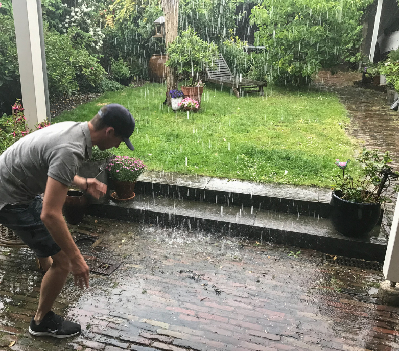 Heavy rainstorm in a residential backyard with water pooling on the surface due to blocked/inefficie