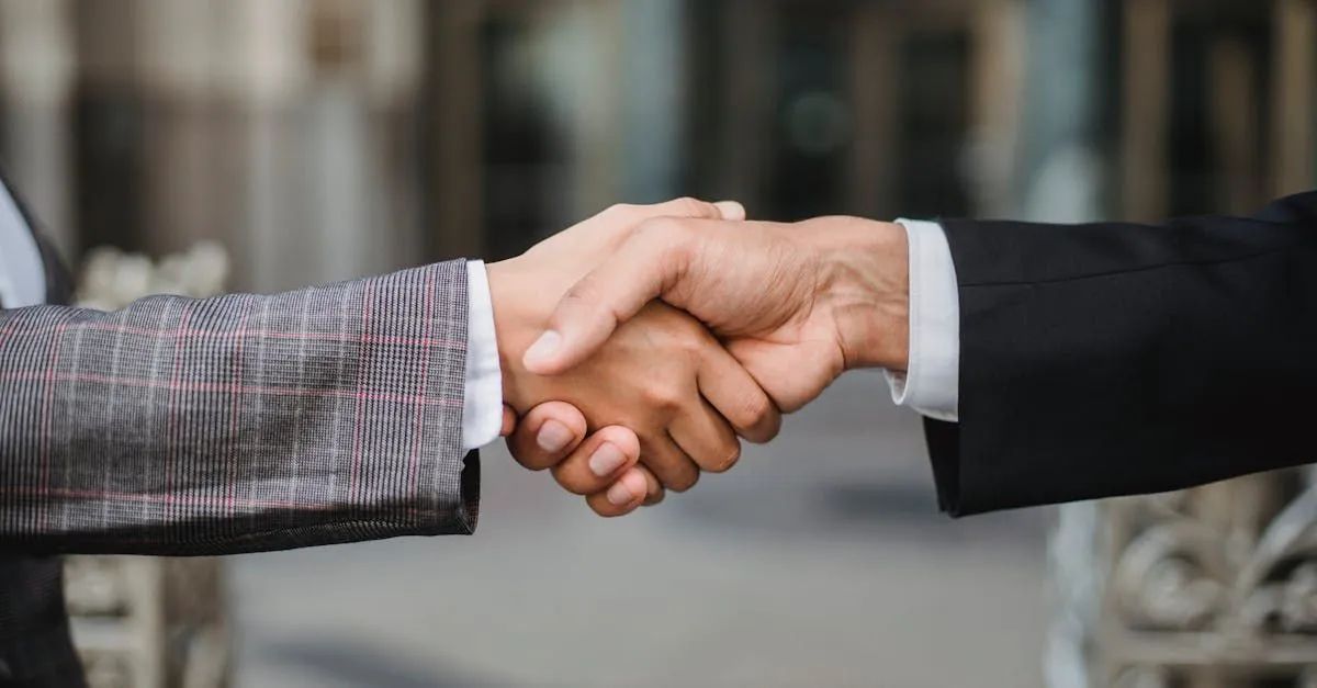 A man and a woman are shaking hands in front of a building.