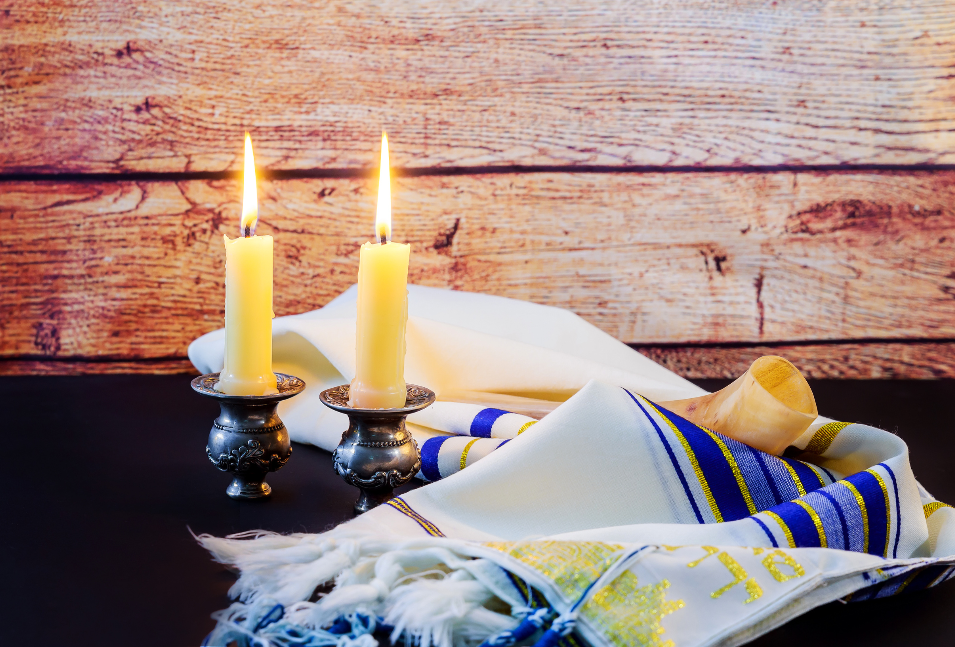 There are two candles and a shofar on the table.