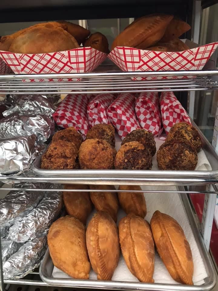 Shelves with fried food: pies in red-checkered baskets, fried balls, and golden pastries.