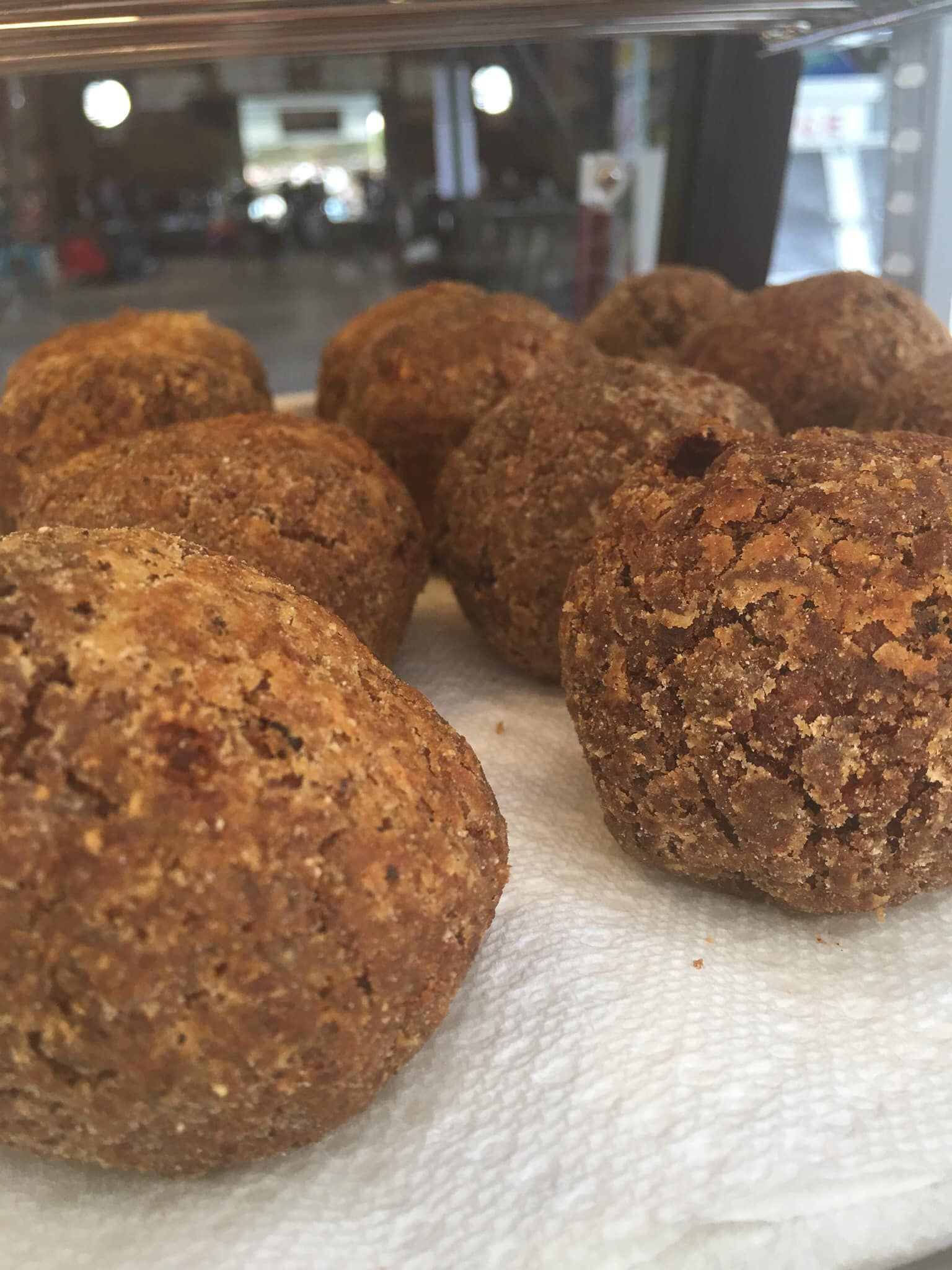 Close-up of several round, brown fried dough balls sitting on a white paper towel.