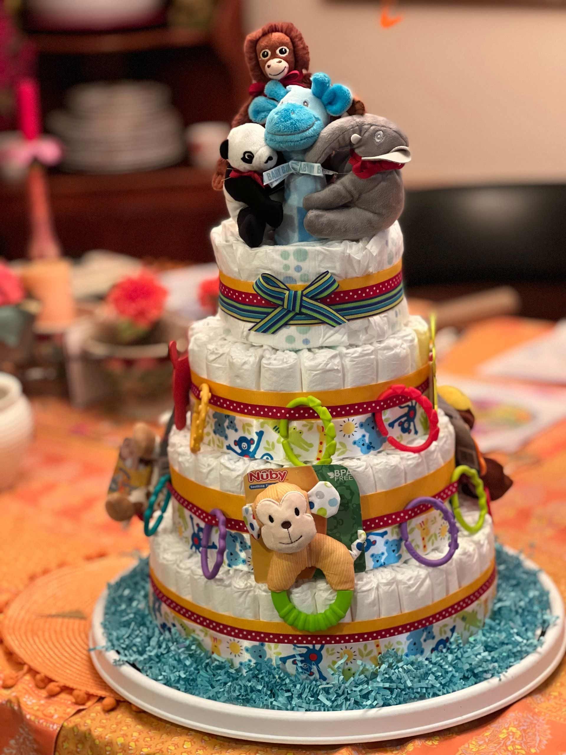 Diaper cake decorated with stuffed animals and colorful ribbon