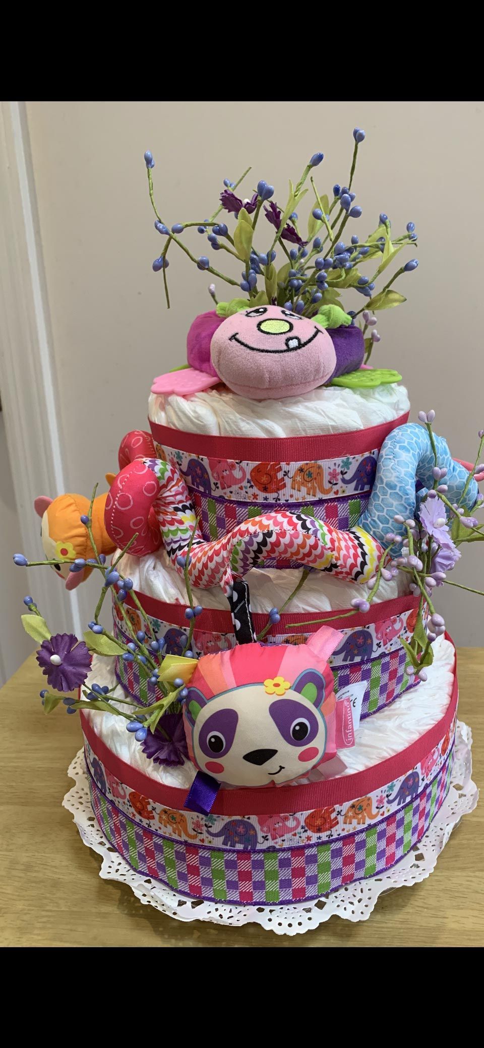 A three-tiered diaper cake decorated with toy animals