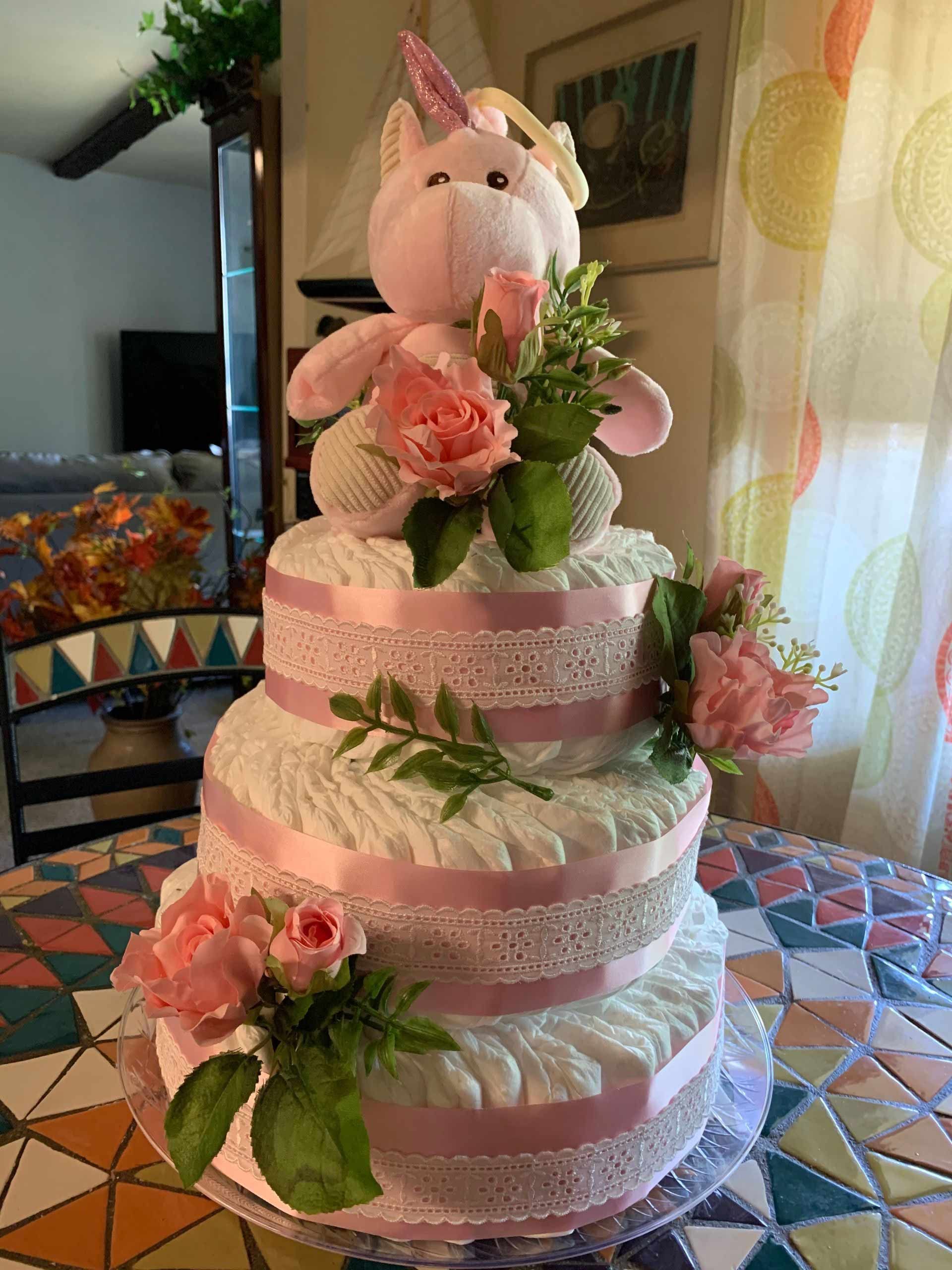 Three-tier diaper cake decorated with unicorn topper