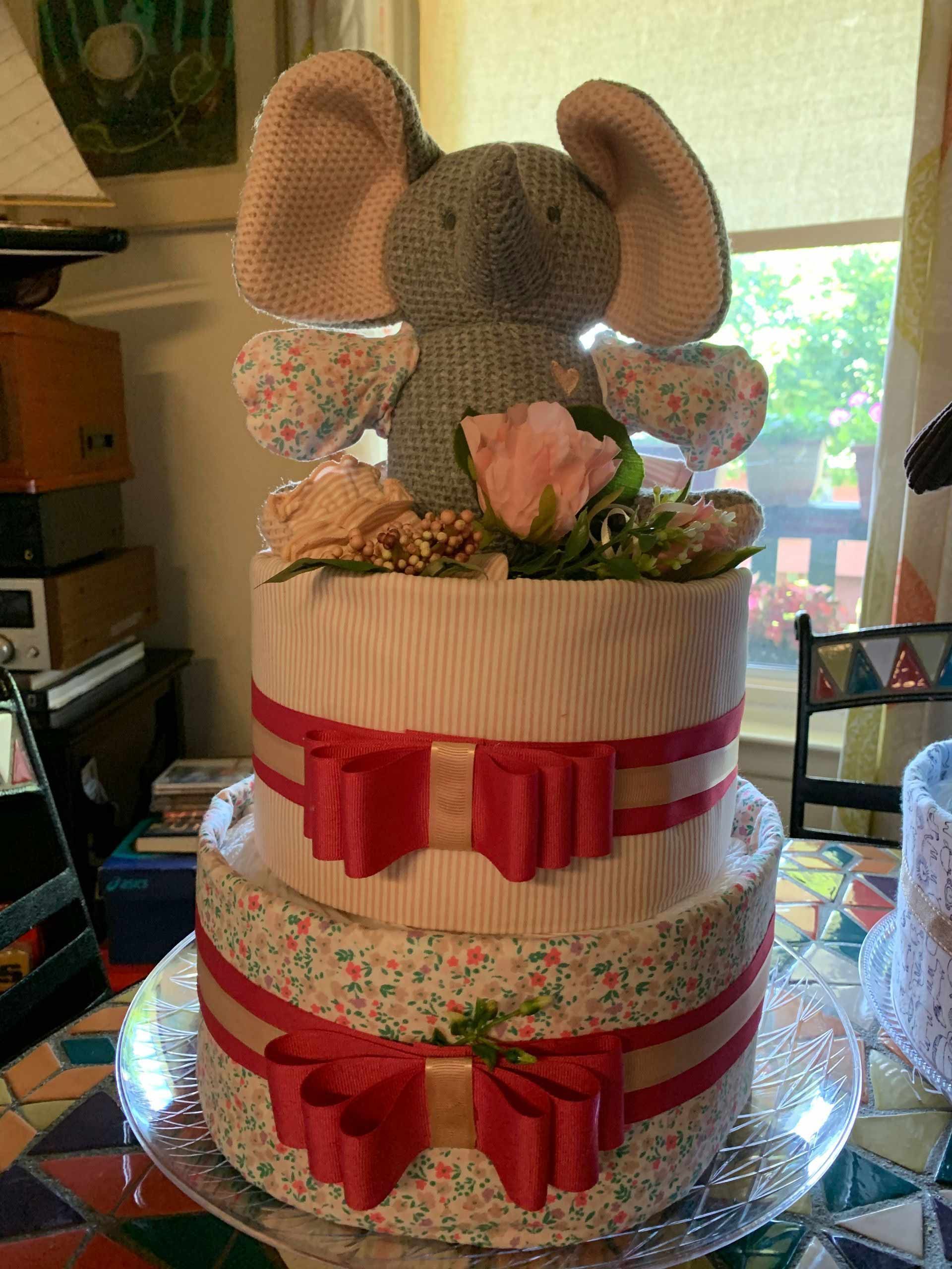 A gray elephant sits on top of diaper cake