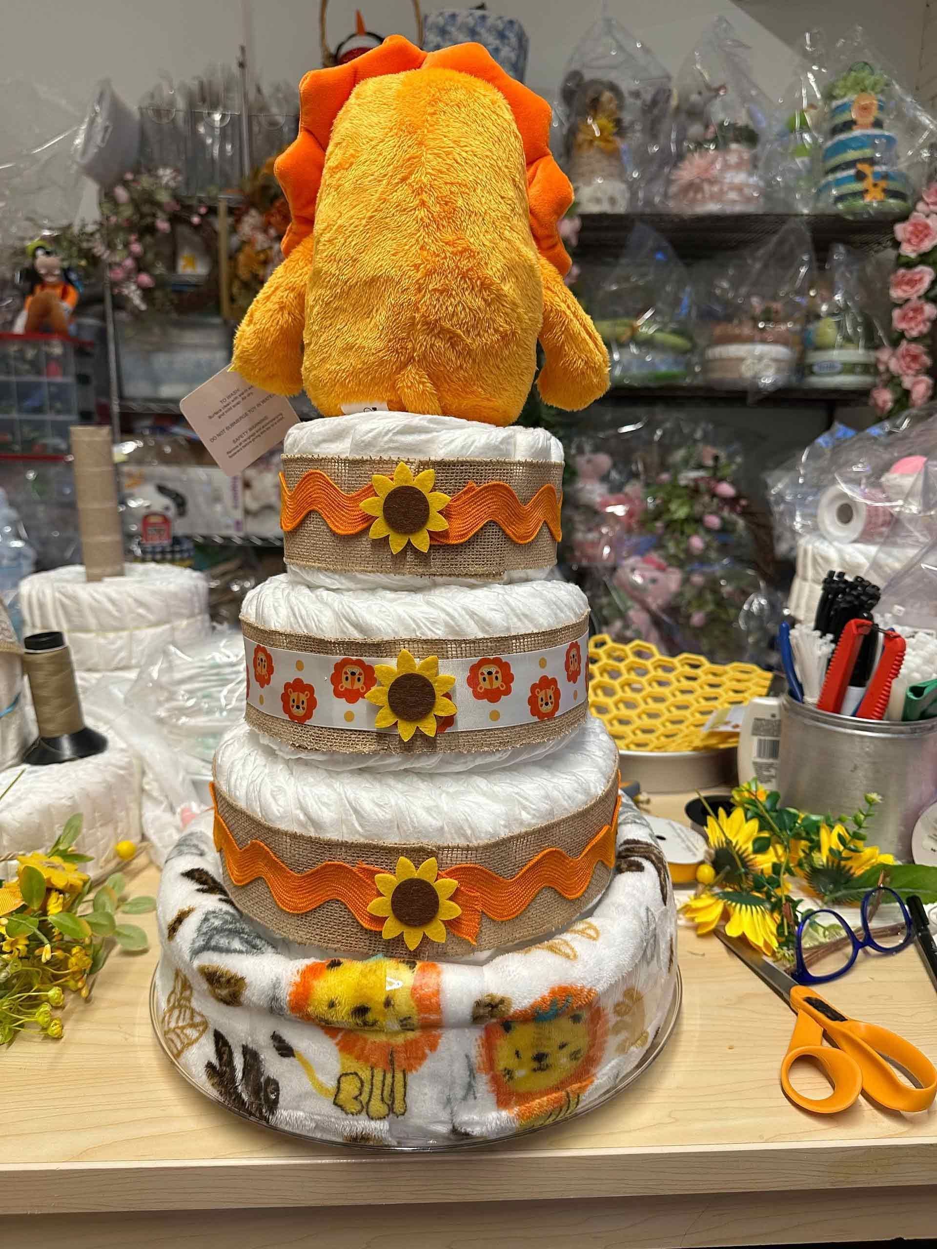 Back of diaper cake with a plush lion topper