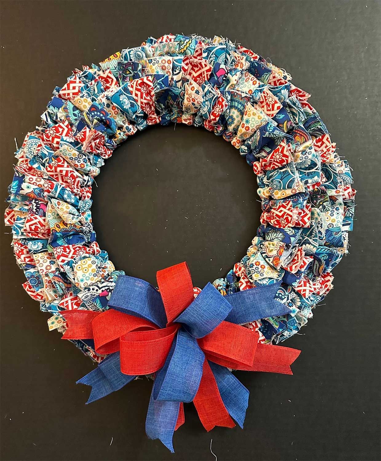 Patriotic rag wreath with red, white, and blue fabrics and ribbon