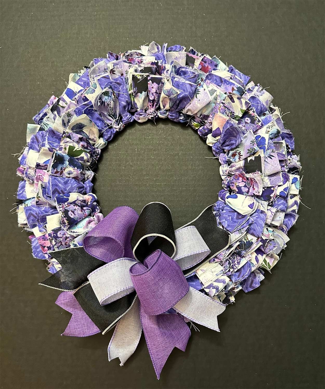 Wreath made of fabric scraps, purple and white, with a ribbon bow