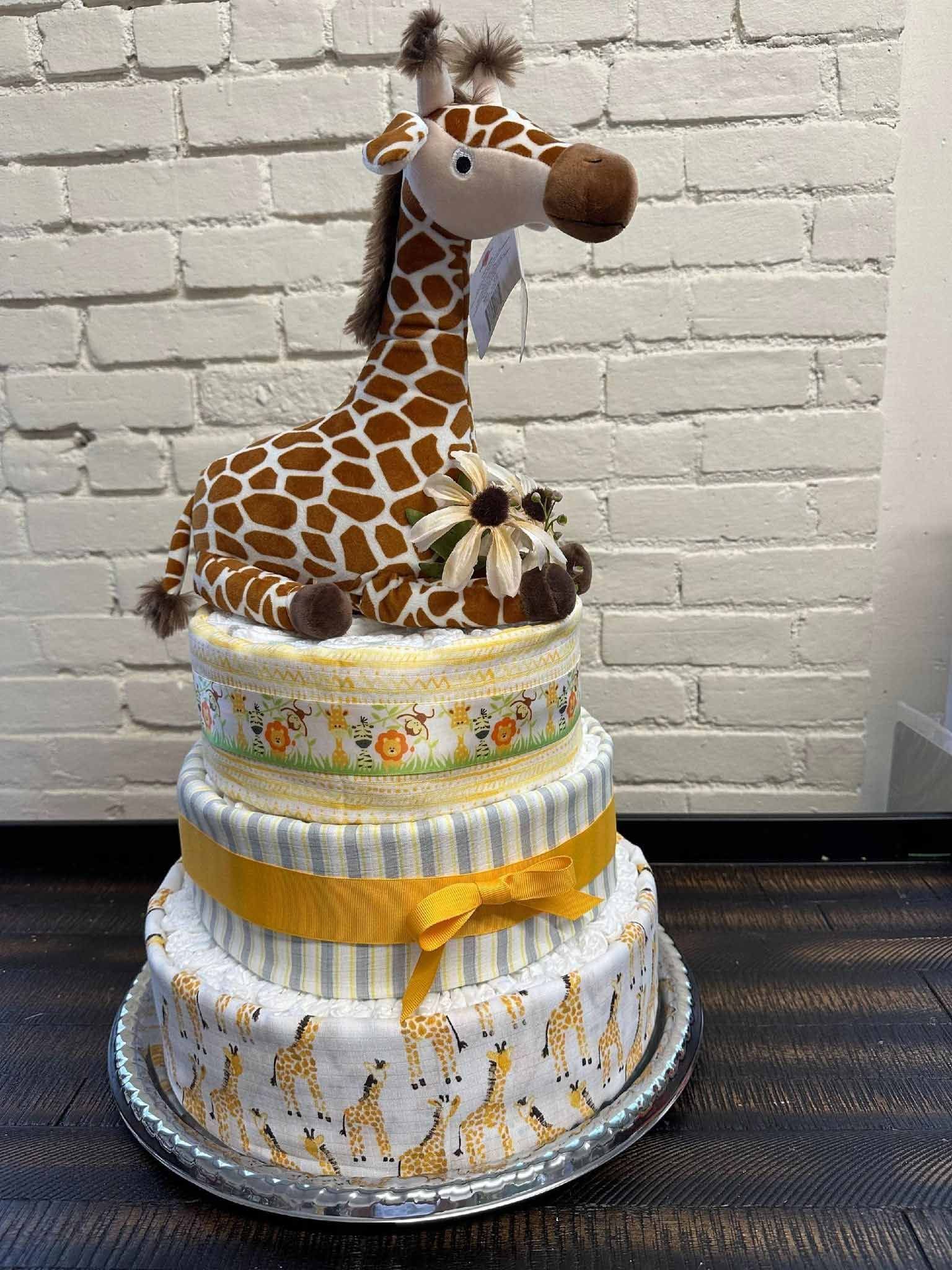 Three-tiered diaper cake with a giraffe plush on top