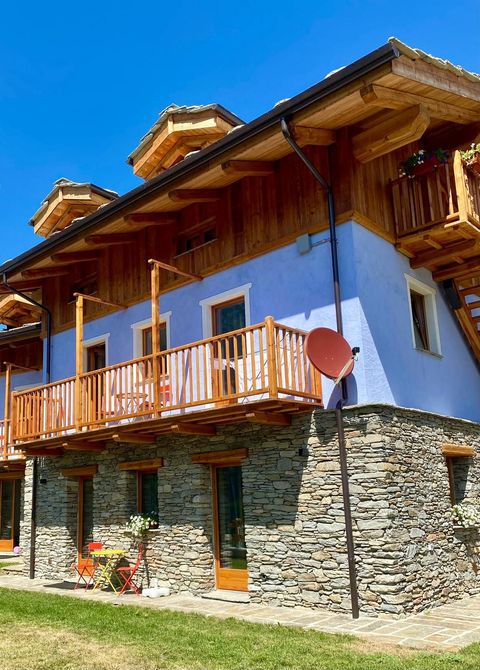 Una mano che mescola un cappuccino schiumoso in una tazza nera Mado, un croissant e dei bicchieri d'acqua su un tavolo.