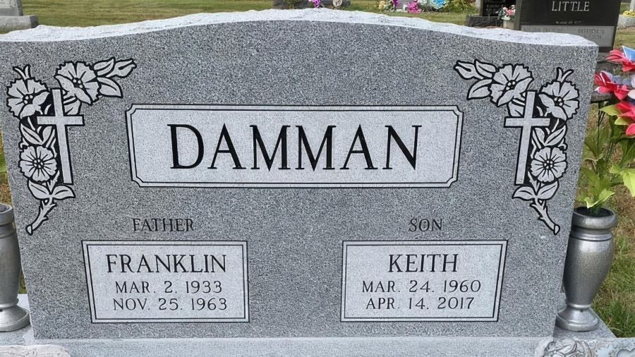 A brick building with a lot of windows is sitting on the side of the road.