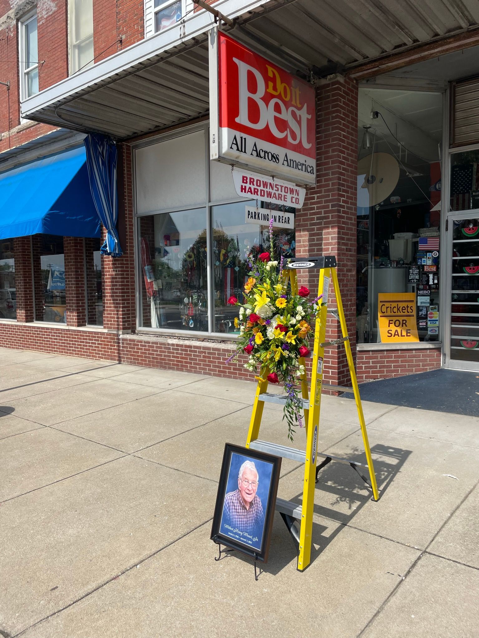 A brick building with a lot of windows is sitting on the side of the road.